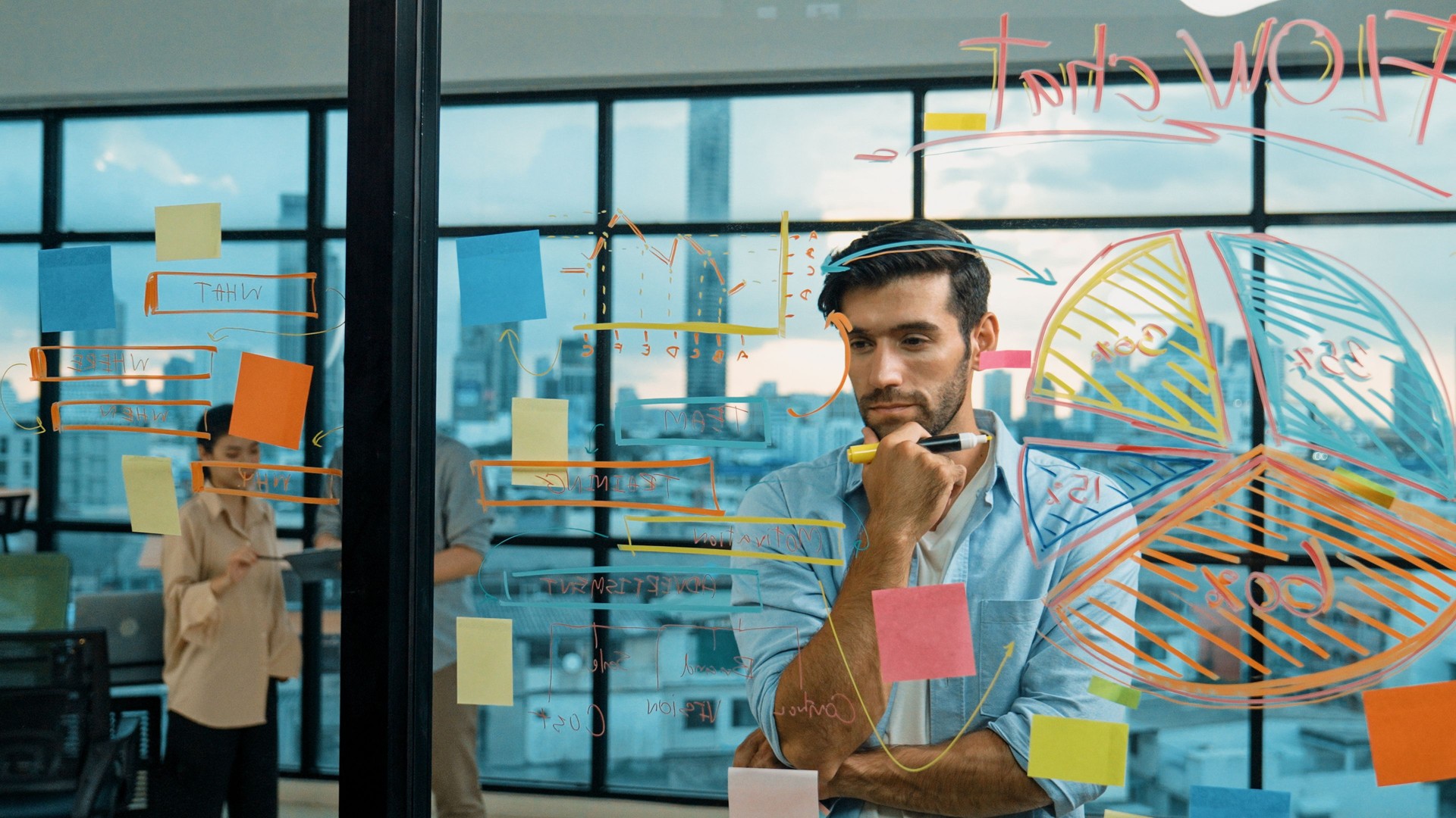 Manager looking sticky notes at glass wall while planing strategy. Tracery